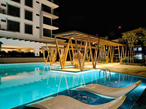 a swimming pool in front of a building at night at K Avenue Kota Kinabalu in Donggongon