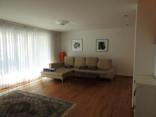 a living room with a couch and a large window at Ferienhaus Heinzle in Koblach