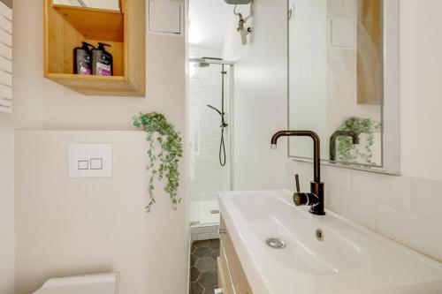une salle de bain blanche avec un lavabo et des toilettes dans l'établissement Parisian Vibe Near Stade de France, 20 min to Champs-Élysées, à Saint-Denis