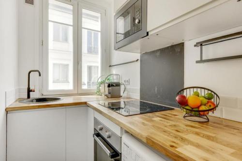une cuisine avec un bol de fruits sur un comptoir dans l'établissement Parisian Vibe Near Stade de France, 20 min to Champs-Élysées, à Saint-Denis