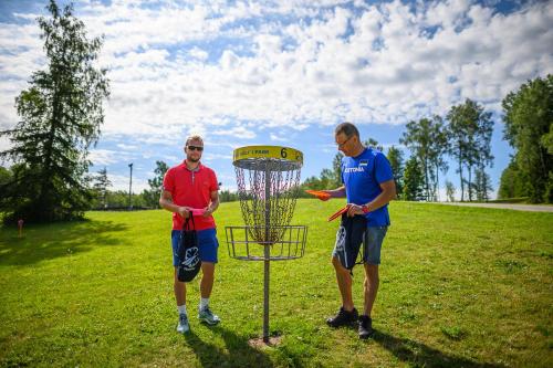 two men are playing a game of frisbee golf at Tehvandi Puhkemaja in Otepää