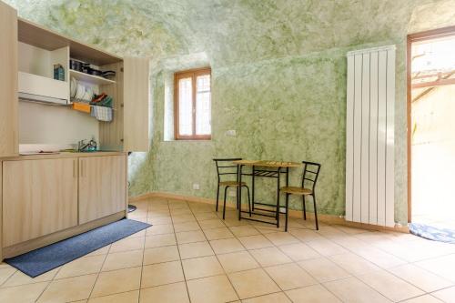 a kitchen with a table and chairs in a room at Secret Zen House in the Center W Free Parking and 24Hours Automatic Check-In - With Netflix & DisneyPlus in Casale Monferrato