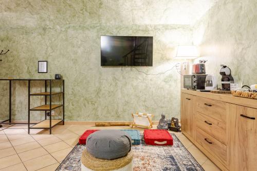 a living room with a flat screen tv on the wall at Secret Zen House in the Center W Free Parking and 24Hours Automatic Check-In - With Netflix & DisneyPlus in Casale Monferrato