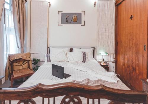 a bedroom with a bed with a laptop on it at Yesterday Hotel in Chiang Mai