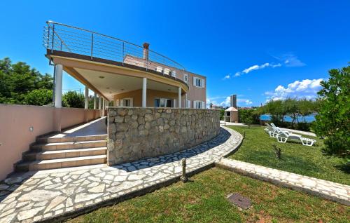 a house with a balcony and a stone wall at Stunning Apartment In Ugljan With Wifi in Ugljan