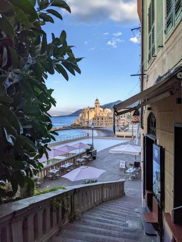 a street with tables and umbrellas and a building at Aqua in Camogli