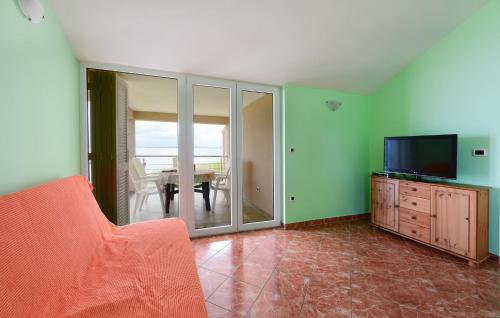 a living room with a couch and a television and a table at Stunning Apartment In Ugljan With Wifi in Ugljan