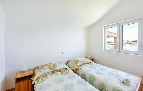 a bedroom with a bed and a window at Stunning Apartment In Ugljan With Wifi in Ugljan