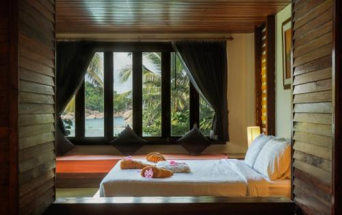 a bedroom with a bed with a view of the ocean at Nangyuan Island Dive Resort in Koh Tao