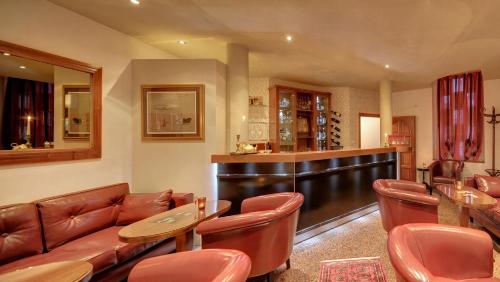 a bar with leather chairs and a couch and tables at Villa Vulin Veruda in Pula