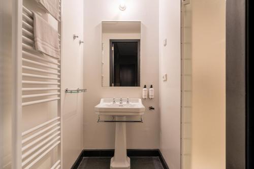 a bathroom with a sink and a mirror at The Hunfeld in Utrecht