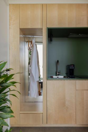 a kitchen with a sink and a robe hanging from a door at The Newel Metaxourgeio in Athens