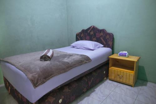 SaonekRaja Ampat Sandy Guesthouse的一间带床和床头柜的小卧室