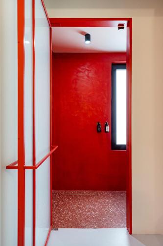 a red door in a room with a red wall at The Newel Metaxourgeio in Athens