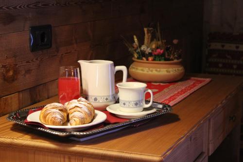 a tray with croissants and cups on a table at Hotel Tersiva in Valtournenche