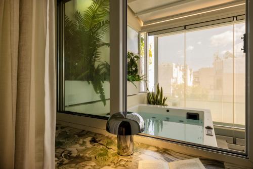 a bathroom with a window with a bath tub in it at The Newel Metaxourgeio in Athens