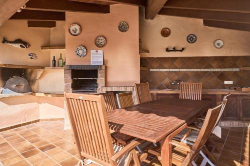 a dining room with a table and chairs and plates on the wall at Finca Puig de Sa Figuera in S'Horta