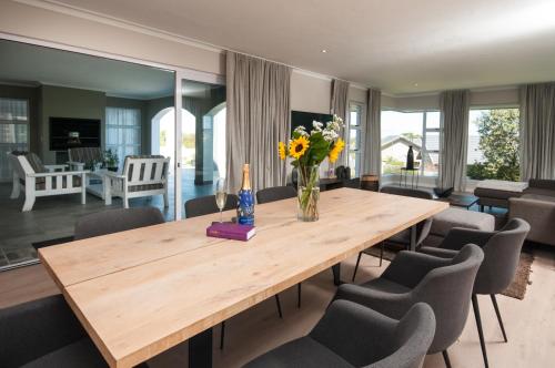a dining room with a wooden table and chairs at Windstar Retreat Knysna in Knysna
