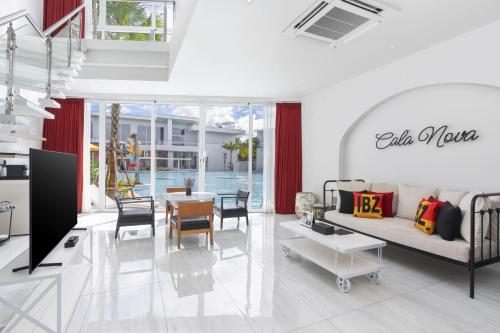 a living room with a couch and a table at The Gems Mining Pool Villas Pattaya in Nong Prue