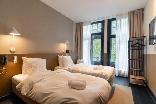 a hotel room with two beds and a window at The Hunfeld in Utrecht