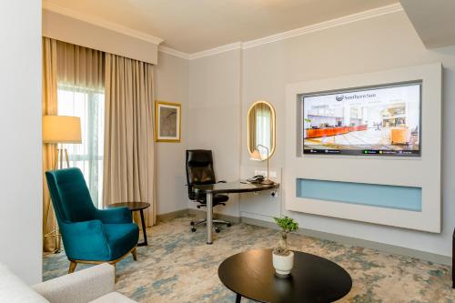 a living room with a tv on a wall at Southern Sun Sandton in Johannesburg