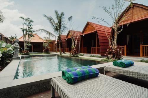 a swimming pool with two chaise lounges next to a resort at Maha Villa Kelating in Krambitan