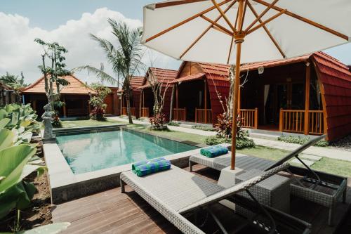 a resort with a swimming pool and an umbrella at Maha Villa Kelating in Krambitan