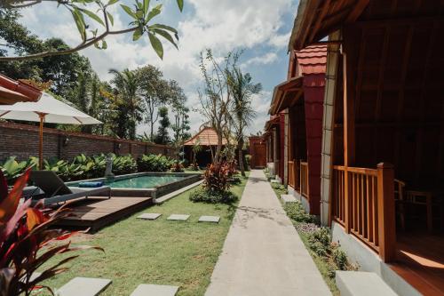 a backyard with a swimming pool next to a house at Maha Villa Kelating in Krambitan