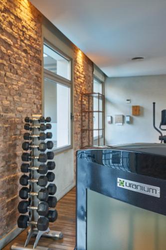 a living room with a television and a brick wall at Almarena Madero Urbano Affiliated by Melia in Buenos Aires