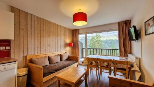 - un salon avec un canapé et une table à manger dans l'établissement Residence les Pleiades, à Flaine