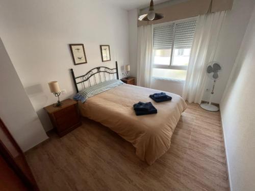 a bedroom with a bed with two towels on it at Apartamento a unos pasos de la Playa (Rota) in Rota