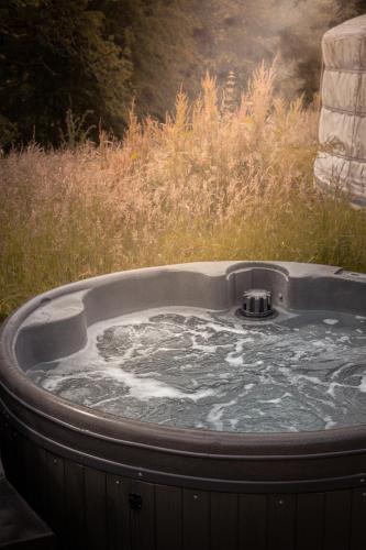 a jacuzzi tub in the middle of a field at Gilfach Gower Farm Luxury Yurt with Hot Tub in Ammanford