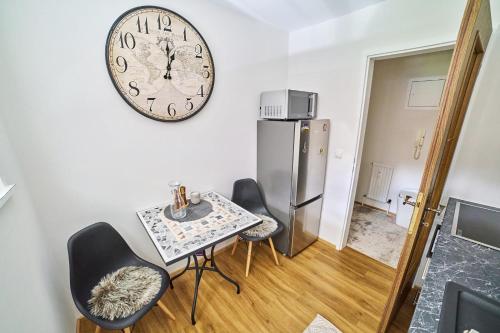 a dining room with a table and a clock on the wall at Apartment Mountainview in Bürs