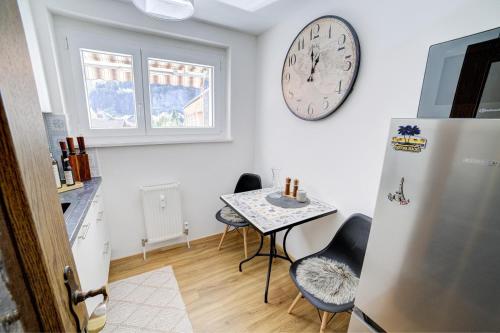 a kitchen with a table and a clock on the wall at Apartment Mountainview in Bürs