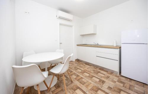 cocina con mesa blanca y sillas blancas en Cozy Apartment In Donji Vinjani, en Donji Vinjani
