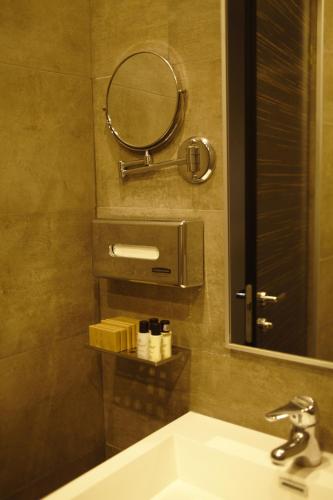 a bathroom with a sink and a mirror at Opera Suite Hotel in Yerevan