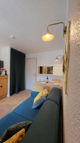 un salon avec un canapé bleu et une chambre dans l'établissement Val Claret-Ski aux pieds, 4 pers, 1 chambre, Balcon Sud, à Tignes