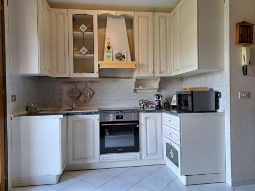 a kitchen with white appliances and white cabinets at Casa Grace Pula in Pula
