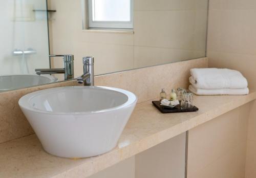 a bathroom with a white sink and a mirror at Almarena Madero Urbano Affiliated by Melia in Buenos Aires
