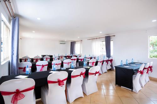 a conference room with tables and chairs with red bows at Melvic Hotel in Kisumu