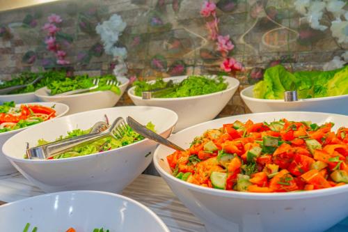 una tabella ricoperta di ciotole di diversi tipi di ortaggi di Sayanora Hotel - All Inclusive a Side