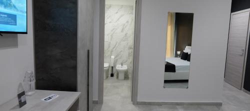 a bathroom with a mirror and a sink and a bed at Hotel Movida in Casoria