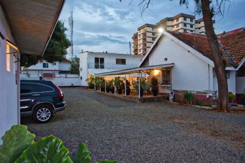 a car parked in a parking lot next to a building at Melvic Hotel in Kisumu