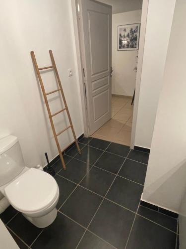 La salle de bains est pourvue de toilettes et de carrelage noir. dans l'établissement Studio rénové au calme, à Dole