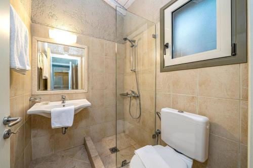 a bathroom with a toilet and a sink and a mirror at Villa Kalou Cottage by Villa Plus in Mousata