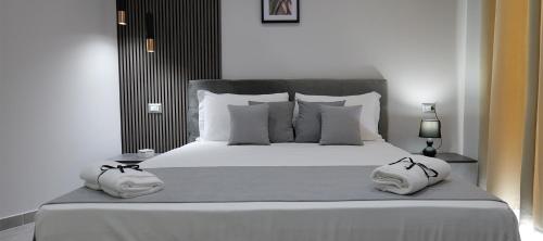 a bedroom with a white bed with two towels on it at Hotel Movida in Casoria