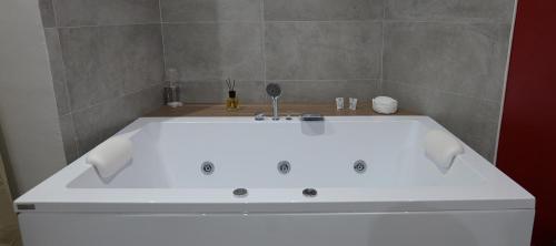 a white bath tub in a bathroom at Hotel Movida in Casoria