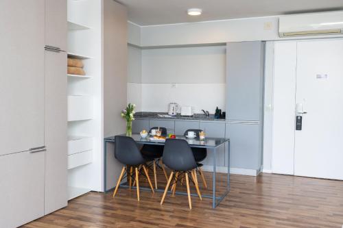 a kitchen with a table and four chairs at Almarena Madero Urbano Affiliated by Melia in Buenos Aires