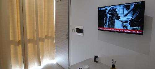 a bathroom with a television on a wall at Hotel Movida in Casoria