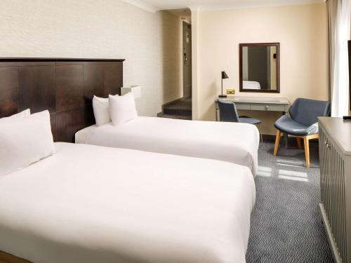 a hotel room with two beds and a desk at Sunday London Staines-upon-Thames Heathrow T5 in Staines